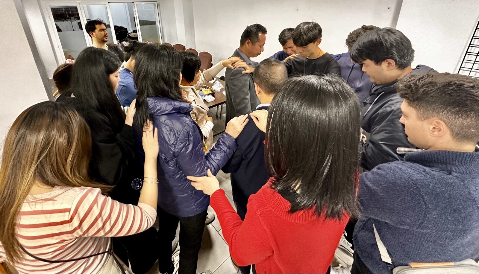 Grupo de personas orando juntas durante un encuentro de la fundación